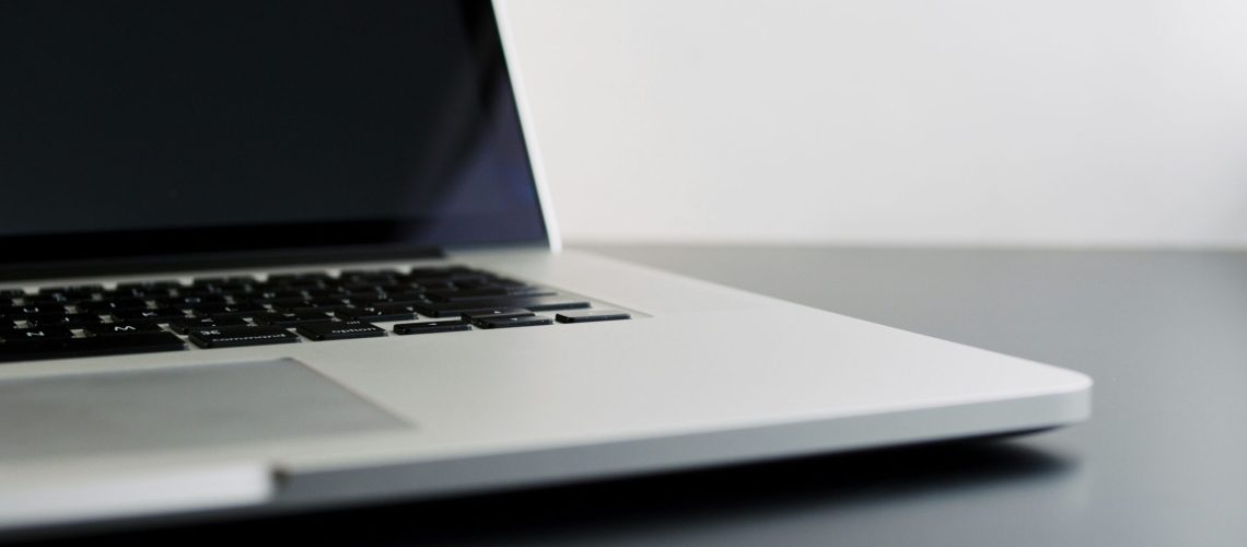 silver laptop computer on black table