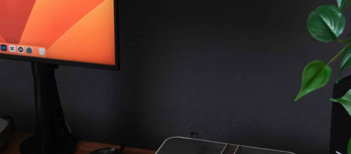a desk with a laptop, keyboard, mouse and a monitor