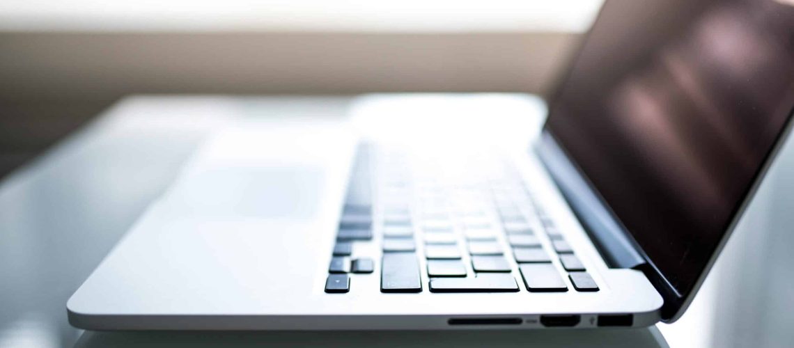 Free Elegant side view of a laptop on a glossy table with natural lighting indoors. Stock Photo